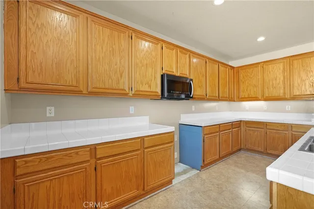 a kitchen with stainless steel appliances granite countertop wooden cabinets a stove top oven with a sink and dishwasher