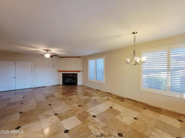 a view of an empty room with a window and fireplace