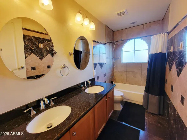 a bathroom with a granite countertop sink mirror and tub