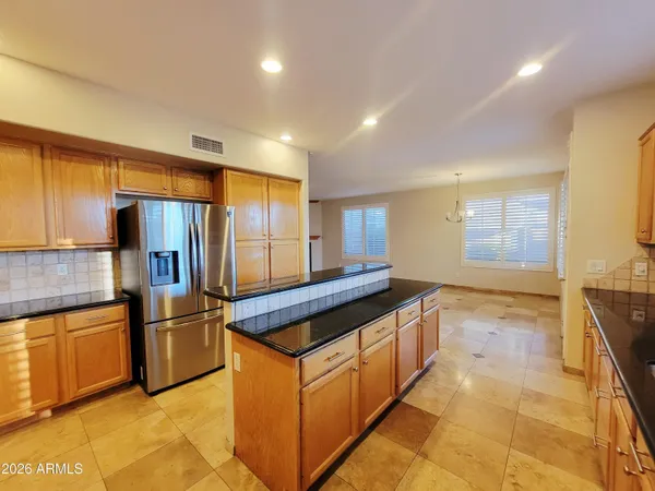 a kitchen with stainless steel appliances granite countertop a refrigerator and a stove top oven