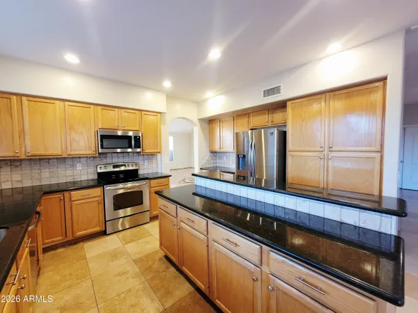 a kitchen with stainless steel appliances granite countertop a stove a sink and a microwave