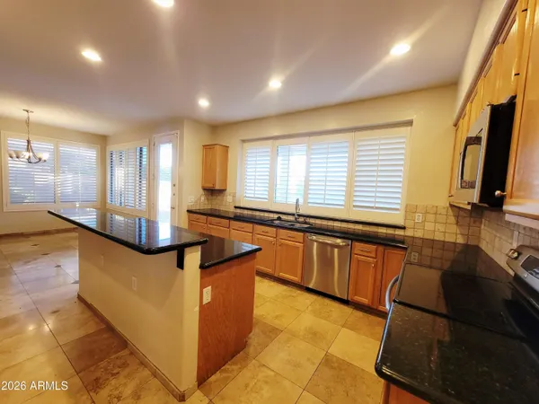 a kitchen with stainless steel appliances granite countertop a sink and a stove