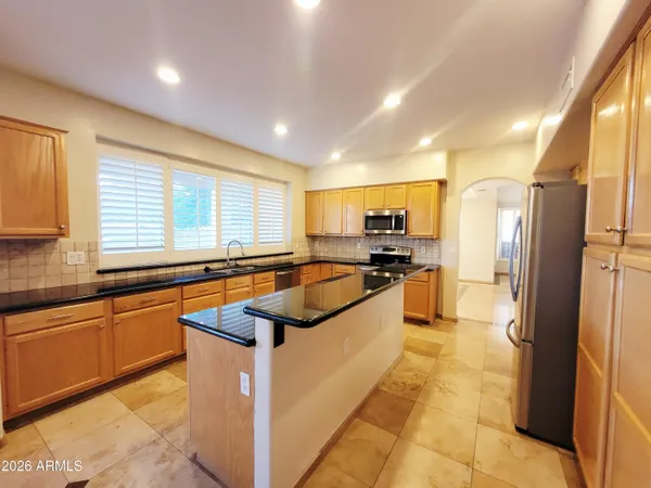 a large kitchen with stainless steel appliances granite countertop a sink and cabinets