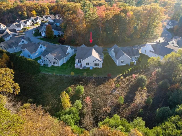 an aerial view of a house with a yard and lake