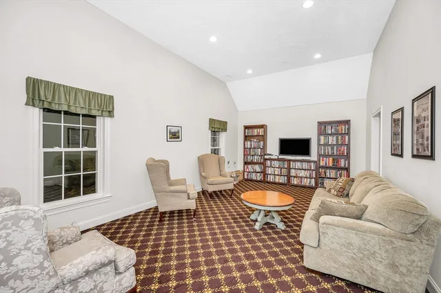 a living room with furniture a flat screen tv and a window