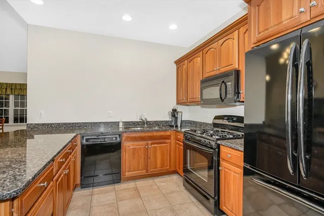 a kitchen with stainless steel appliances granite countertop a stove top oven a sink and dishwasher