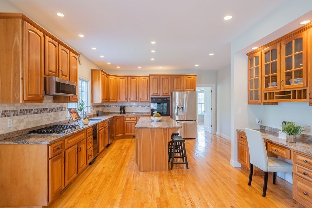 9 Bates Road Lexington, MA 02421 - Photo 13 of 42 a large kitchen with stainless steel appliances granite countertop wooden floors a stove a sink and a island