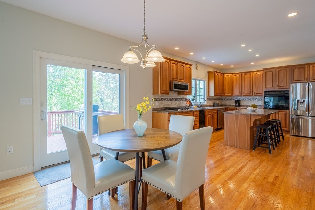 9 Bates Road Lexington, MA 02421 - Photo 17 of 42 a kitchen with stainless steel appliances granite countertop a stove a refrigerator a kitchen island a dining table and chairs
