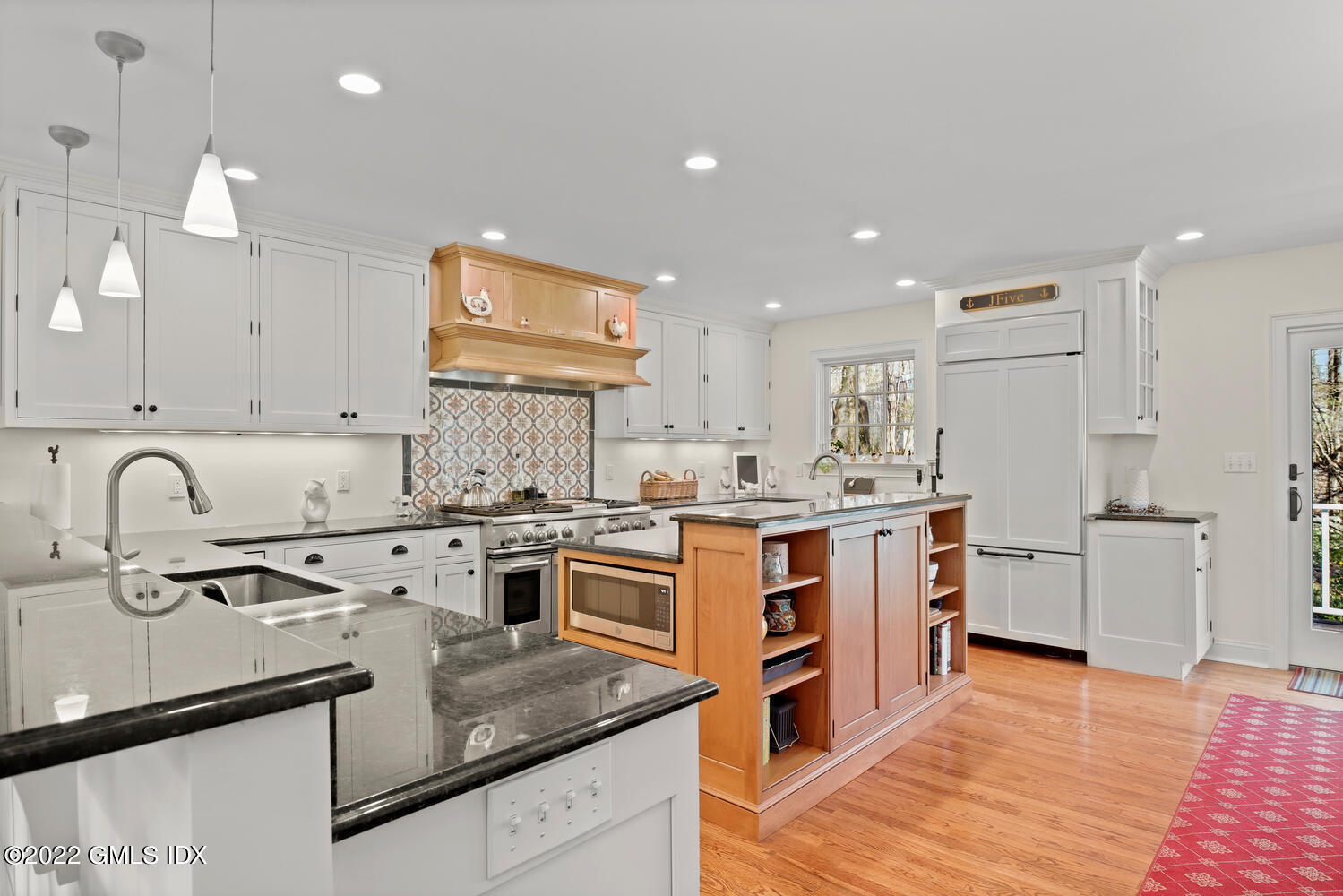 4 Rainbow Drive Riverside, CT 06878 - Photo 14 of 59 a kitchen with stainless steel appliances granite countertop a stove top oven a sink a refrigerator and white cabinets with wooden floor