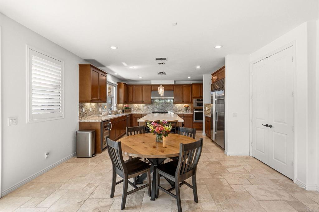 809 Dolphin Circle Encinitas, CA 92024 - Photo 27 of 71 a dining area with a table chairs and a refrigerator
