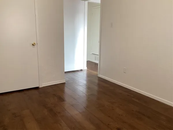 a view of an empty room with wooden floor