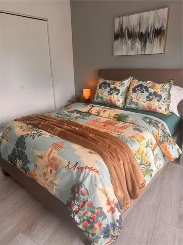 a bedroom with a bed and a painting on the wall