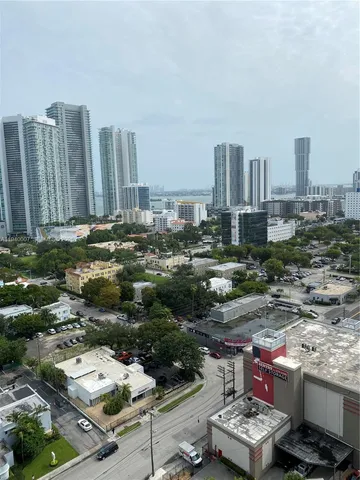 a view of a city from a chairs and table in the balcony
