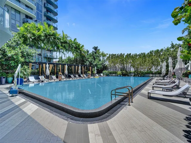 a living room with furniture pool table and a large window