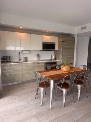 a dining room with a wooden table and chairs