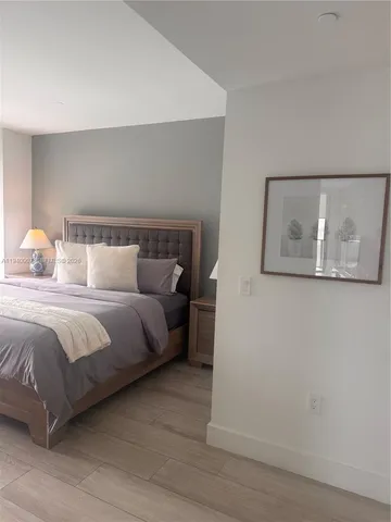 a bedroom with a bed and painting on the wall