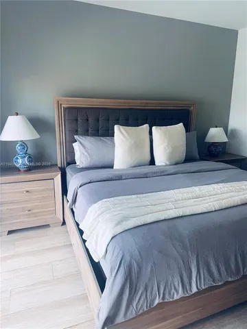 a large bed sitting in a bedroom next to a lamp and a lamp