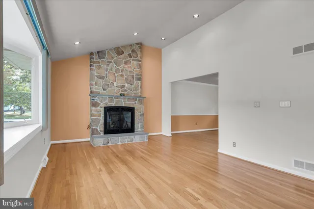 an empty room with wooden floor and fireplace
