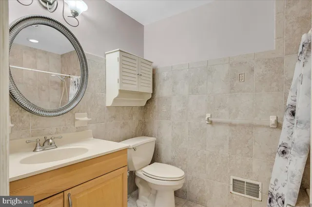 a bathroom with a sink a toilet mirror and vanity