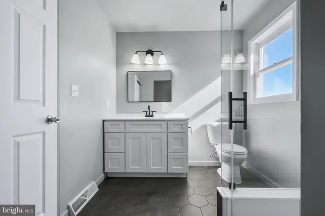 a bathroom with a sink toilet and mirror