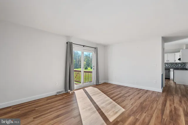 a view of a room with wooden floor and a sink