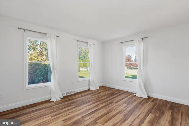 wooden floor in an empty room with a window