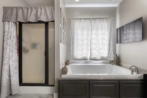 a bathroom with a granite countertop sink and a bathtub