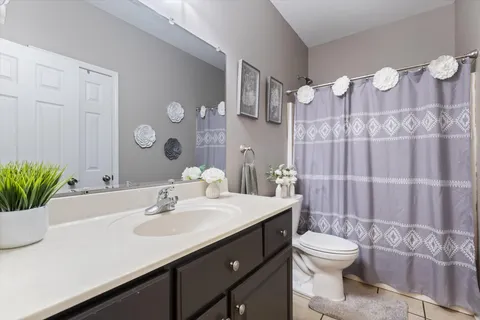 a bathroom with a sink vanity mirror and toilet