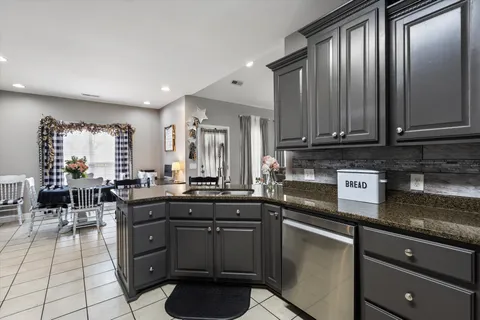 a kitchen with granite countertop a sink a counter space appliances and cabinets