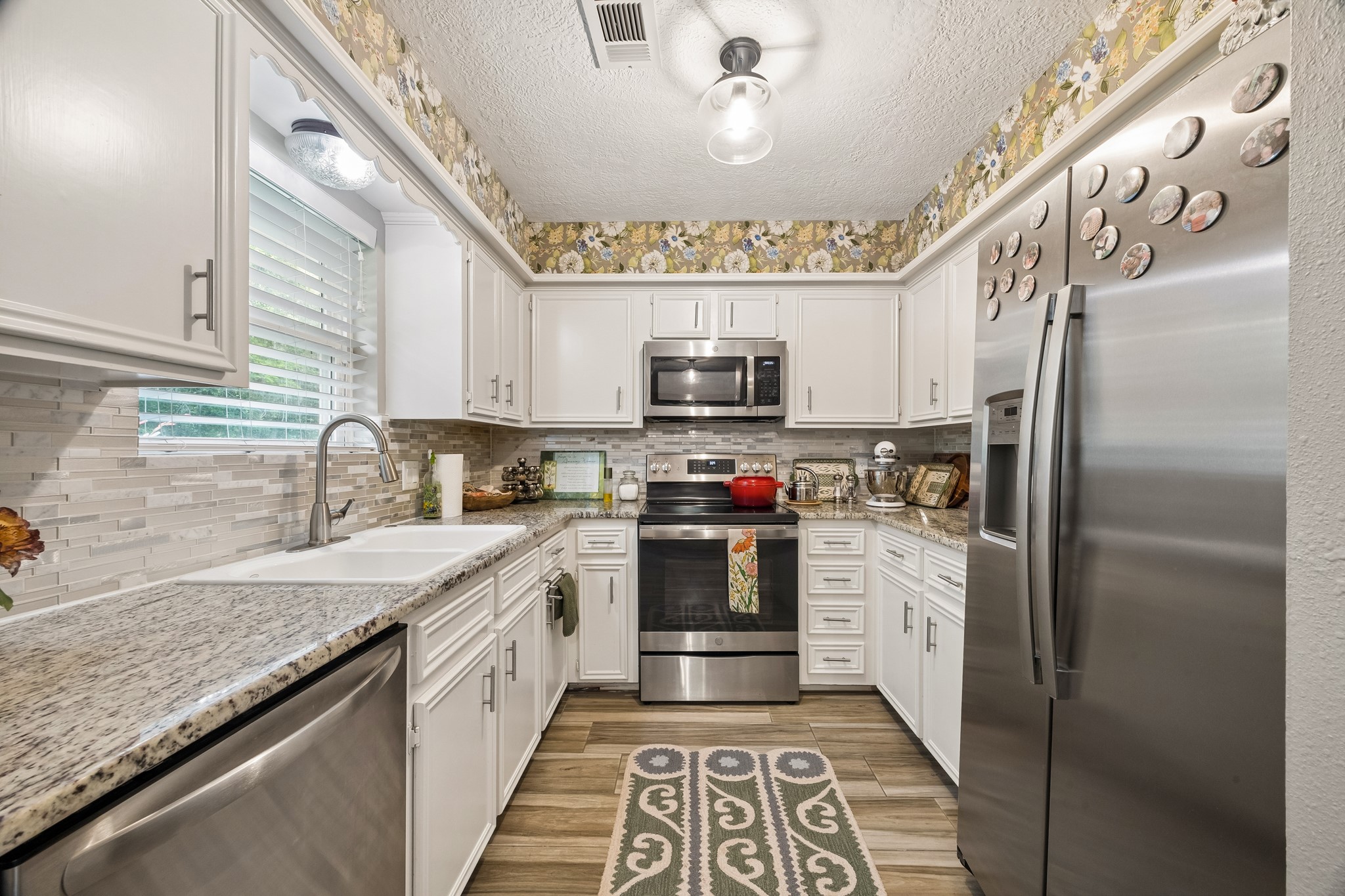 2102 Casa Rio Circle Dickinson, TX 77539 - Photo 6 of 22 The beautifully updated kitchen combines function and style!!! Featuring upgraded stainless-steel appliances, granite countertops, tile backsplash, and abundant storage. Thoughtfully designed pull-out cabinet drawers maximize organization, while the semi-private layout keeps meal preparation and cleanup discreetly tucked away from the main living areas. ***Bonus ~ Seller upgraded all stainless steel appliances ~ approx. 4 yrs old ~ Seller also had cabinetry resurfaced and repainted***