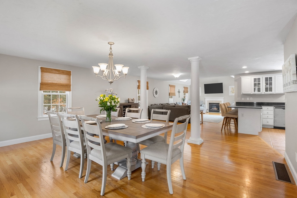 1 Anthony's Way Mashpee, MA 02649 - Photo 12 of 42 a dining room with wooden floor a chandelier a wooden table and chairs