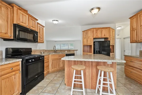 a kitchen with stainless steel appliances granite countertop a stove top oven a sink dishwasher and a microwave oven on the blue kitchen countertops