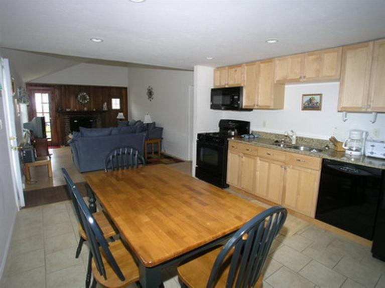 188 Captain Chase Road Dennis Port, MA 02639 - Photo 8 of 14 a kitchen with a stove a sink a microwave a dining table and chairs