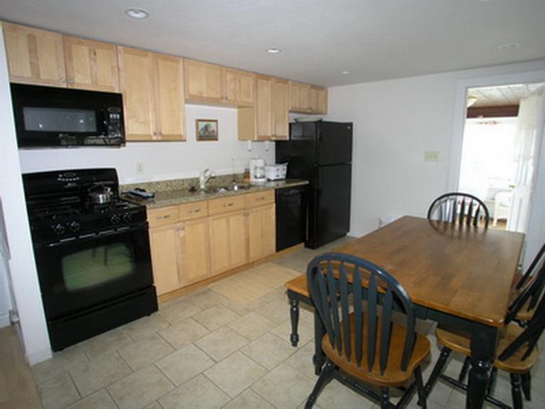 188 Captain Chase Road Dennis Port, MA 02639 - Photo 9 of 14 a kitchen with stainless steel appliances granite countertop a stove a sink a microwave a refrigerator and cabinets
