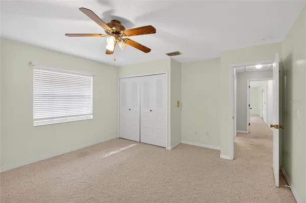 a view of an empty room with a ceiling fan