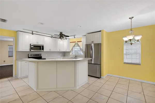 a kitchen with stainless steel appliances a refrigerator sink and microwave