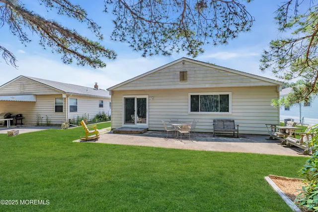 a backyard of a house with table and chairs