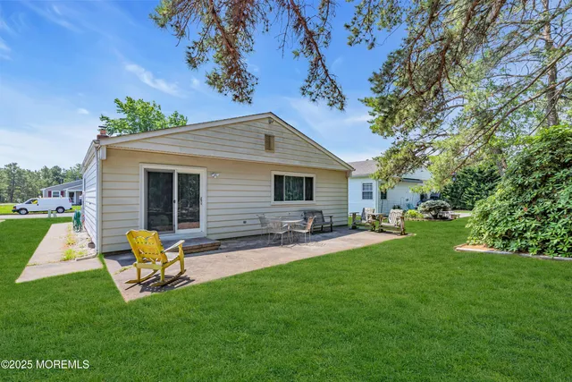 a backyard of a house with table and chairs