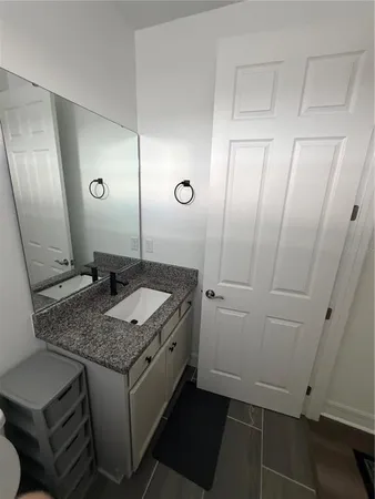 a bathroom with a granite countertop sink and a mirror