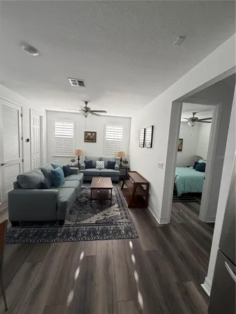 a living room with furniture and a wooden floor