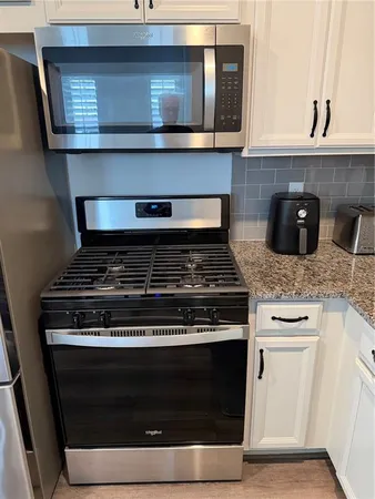 a stove top oven sitting inside of a kitchen