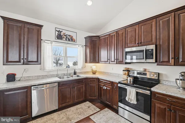 a kitchen with stainless steel appliances granite countertop a sink stove and microwave