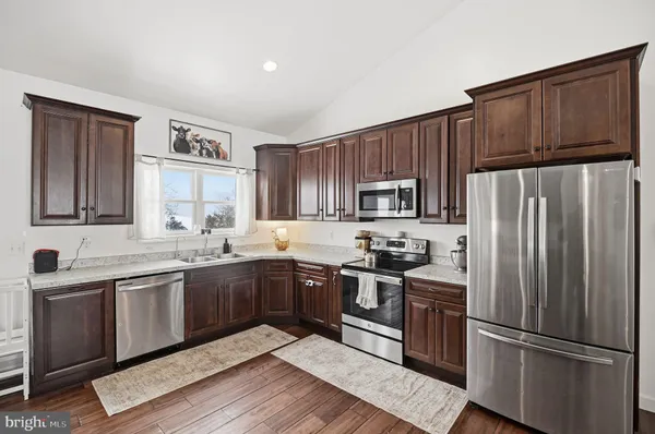 a kitchen with stainless steel appliances granite countertop a refrigerator stove microwave and sink