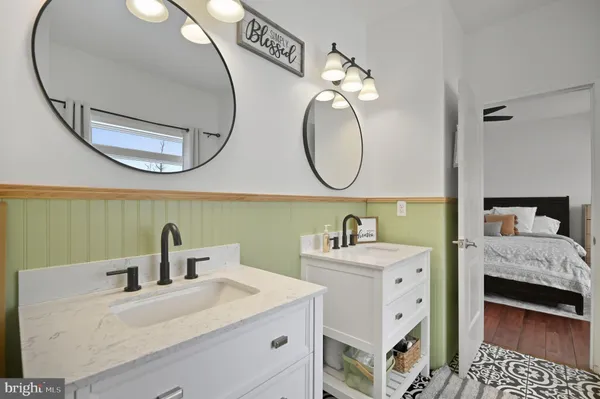 a en suite bathroom with a double vanity sink and a mirror