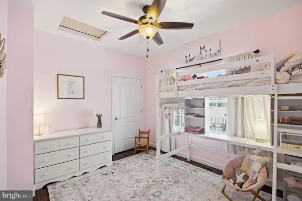 a room with chandelier fan and windows