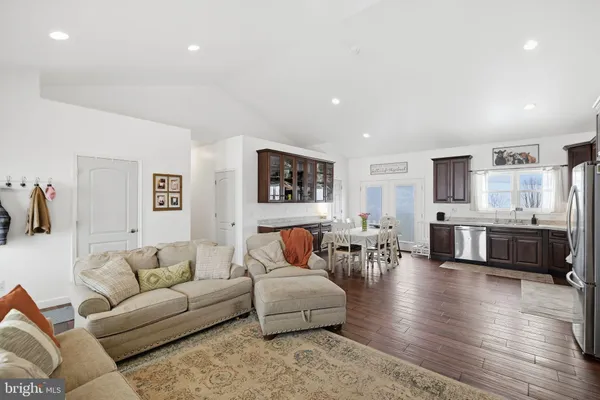 a living room with furniture and view of kitchen