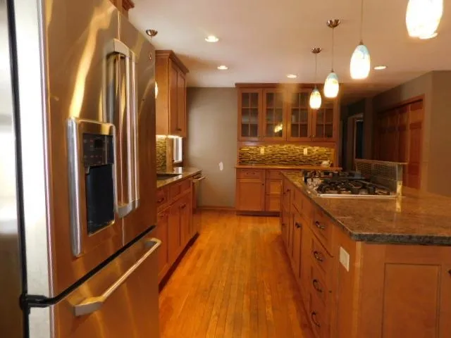 a large kitchen with kitchen island granite countertop a large counter top stainless steel appliances and cabinets