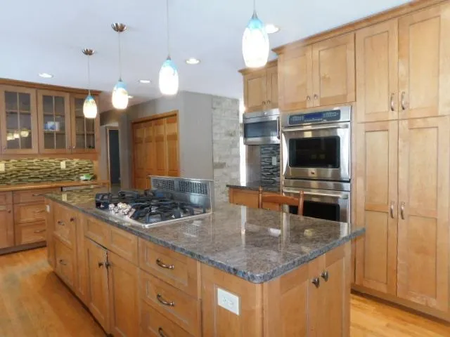 a kitchen with stainless steel appliances granite countertop a sink and cabinets