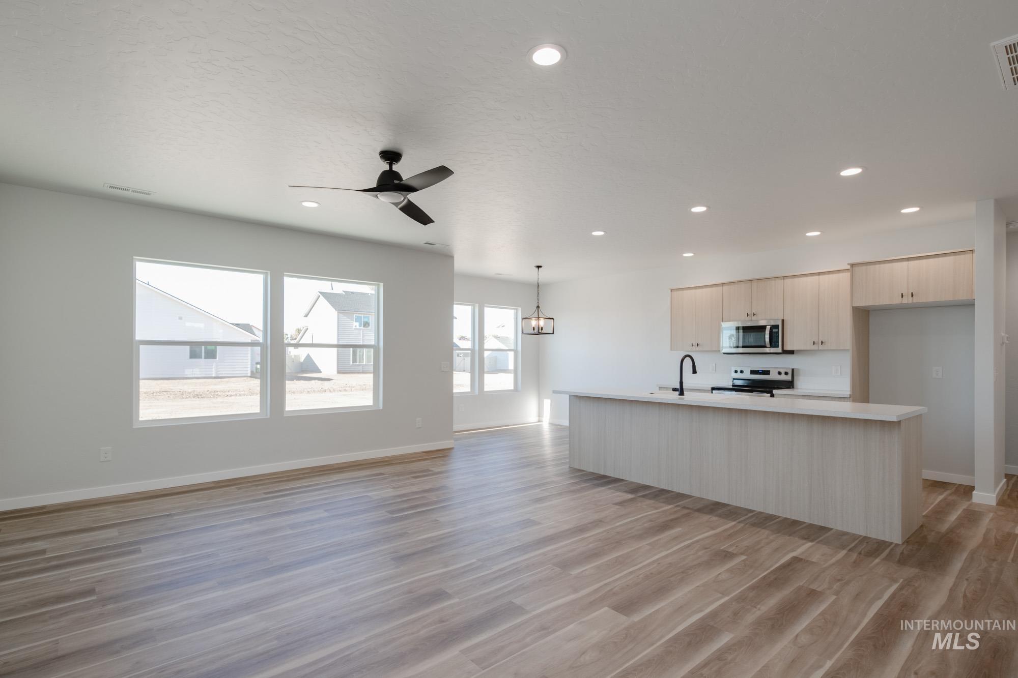 1634 Dyer Street Middleton, ID 83644 - Photo 23 of 25 Kitchen with light countertops, open floor plan, a kitchen island with sink, appliances with stainless steel finishes, and recessed lighting