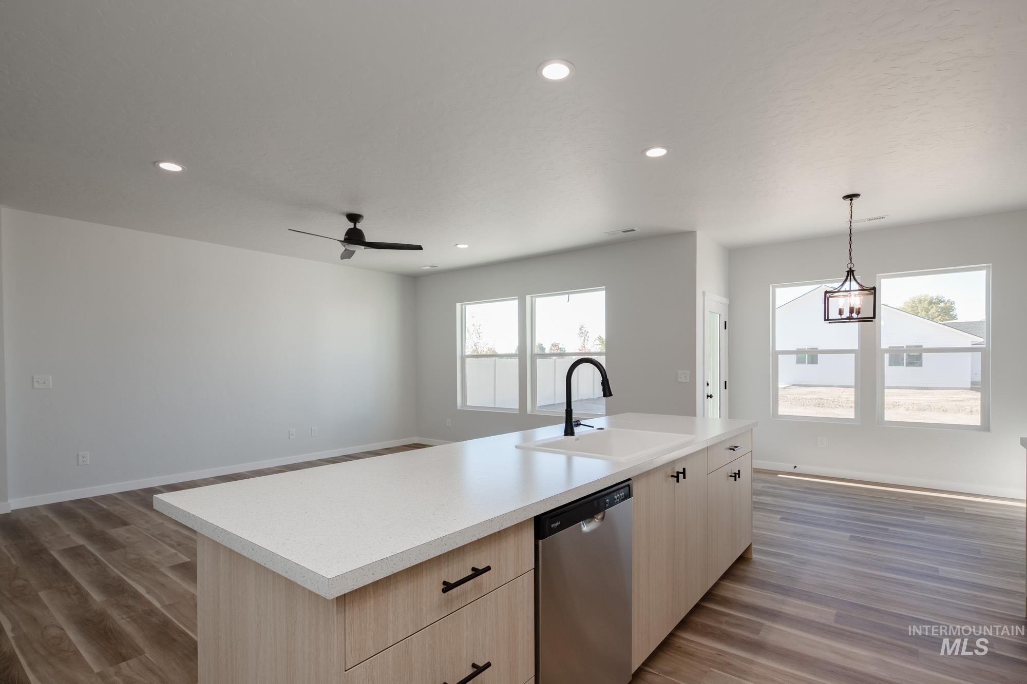 1634 Dyer Street Middleton, ID 83644 - Photo 21 of 25 Kitchen featuring light brown cabinetry, light countertops, open floor plan, light wood-type flooring, and stainless steel dishwasher